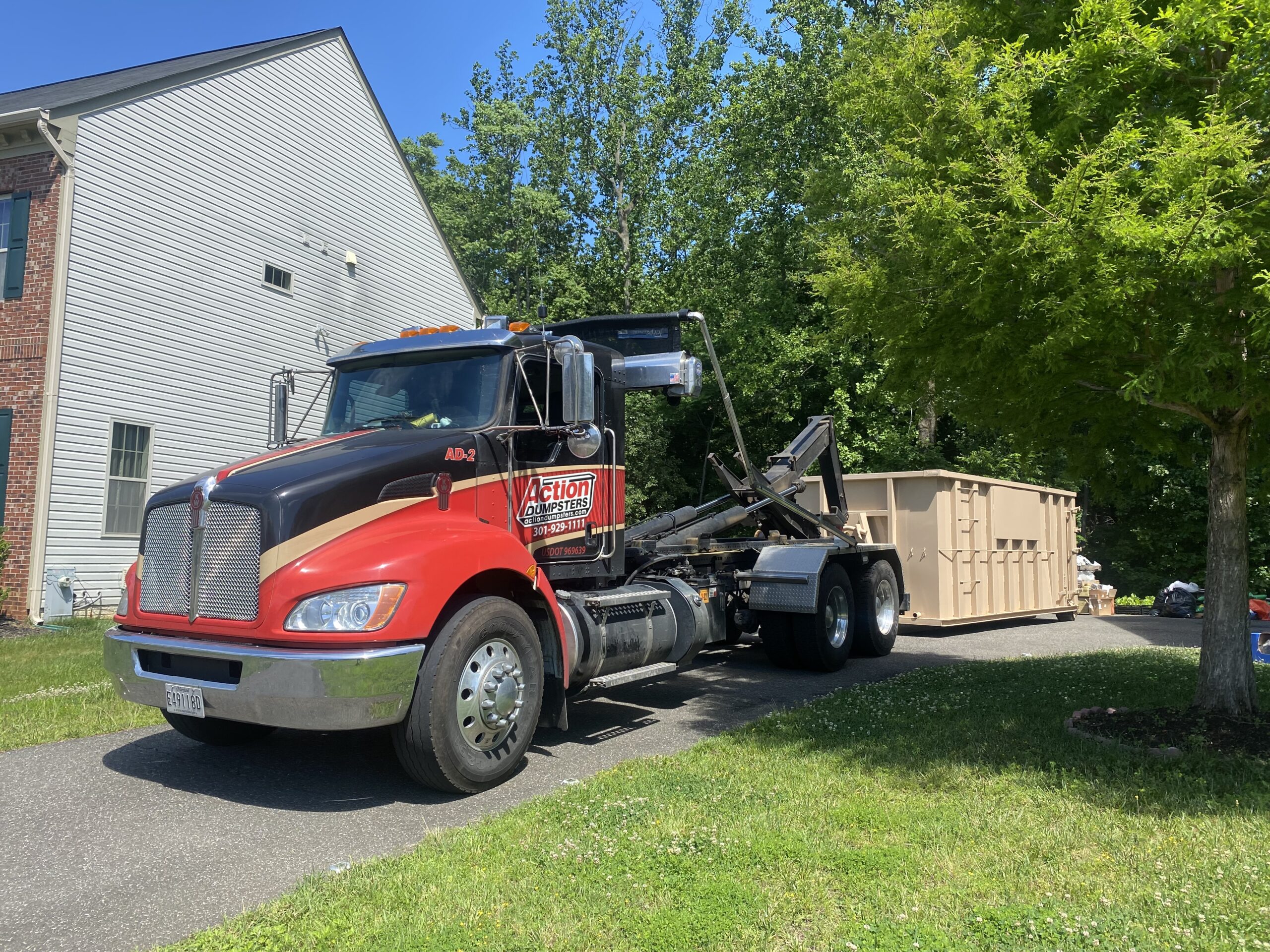 Action Dumpsters truck delivering a roll-off dumpster rental
