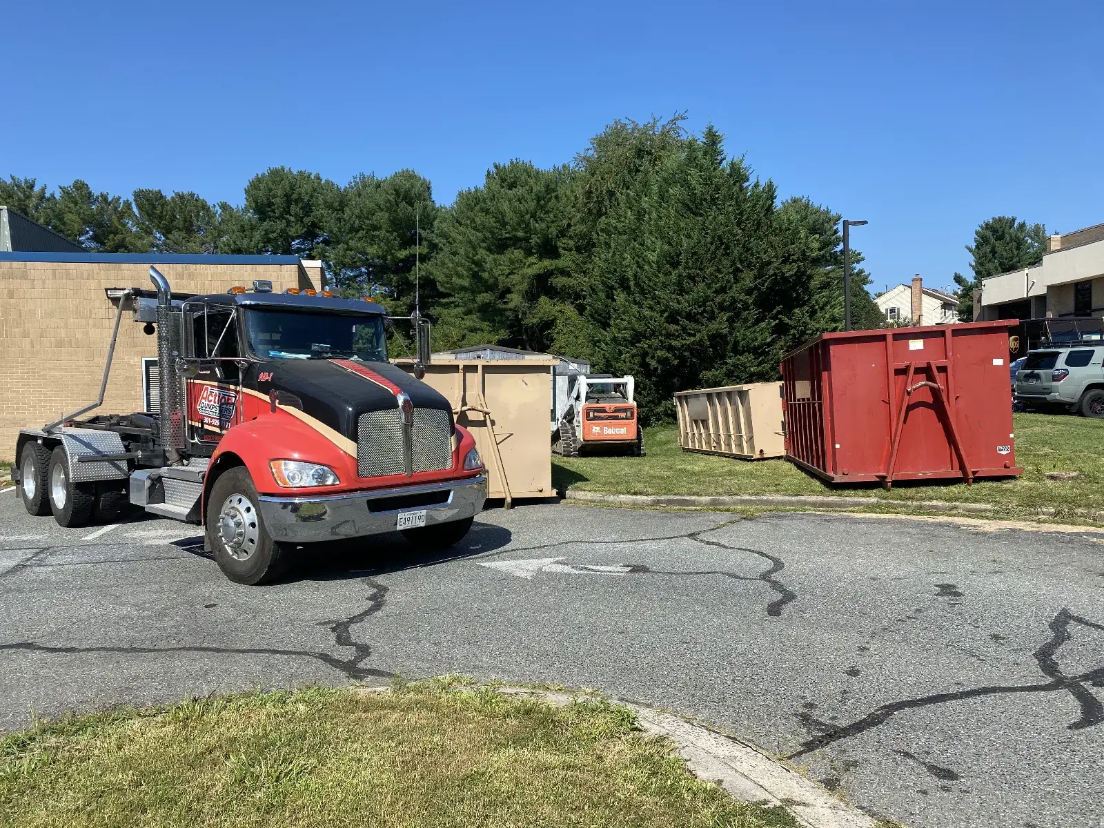Action Dumpsters roll-off truck parked beside roll-off dumpsters